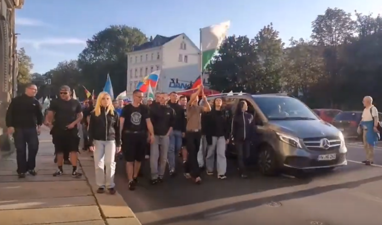 Gruppe um die "Chemnitz Revolte" am 19.08.2024 auf der Montagsdemo in Chemnitz. V.l.n.r.: unbekannt, Kay Ian Fischer, Lina Gertz, Janik Tonat, Noah Schumann, Stanley Scholz, Marvin Kurth (mit Fahne), Lilly Ullmann, unbekannt. (Quelle: Bernd Arnold)